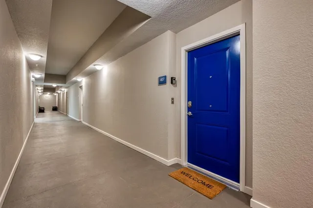 a kitchen with stainless steel appliances kitchen island granite countertop a refrigerator a stove a dining table and chairs with wooden floor