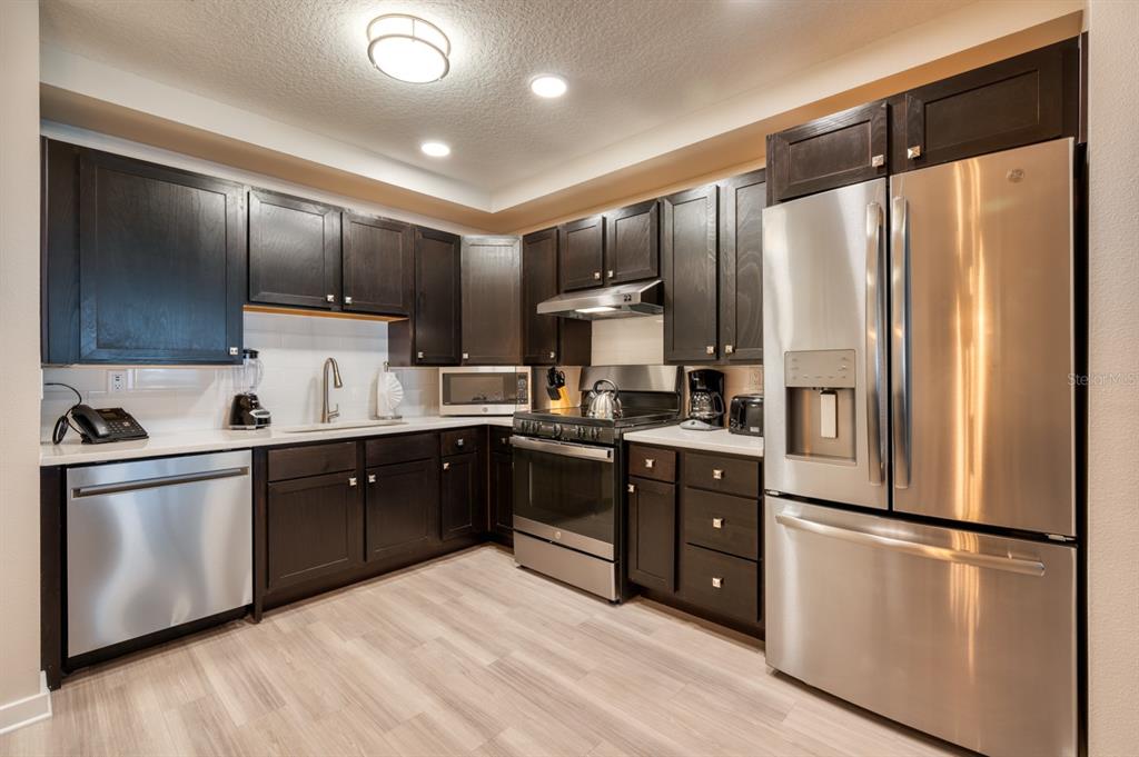 4013 Breakview Drive, Unit A407 Orlando, FL 32819 - Photo 8 of 32 a kitchen with stainless steel appliances a refrigerator sink and cabinets