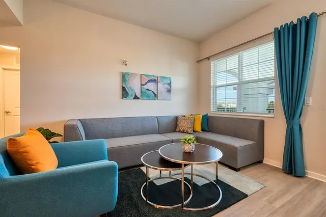 a living room with furniture and kitchen view