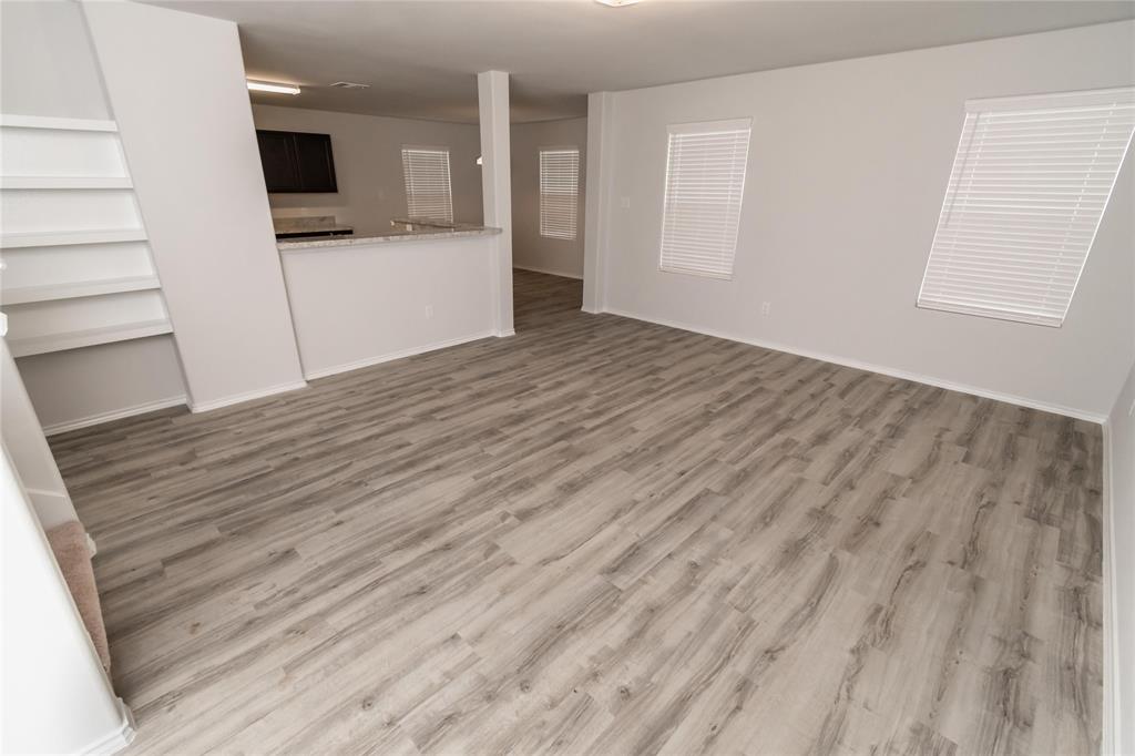 wooden floor in an empty room with a kitchen