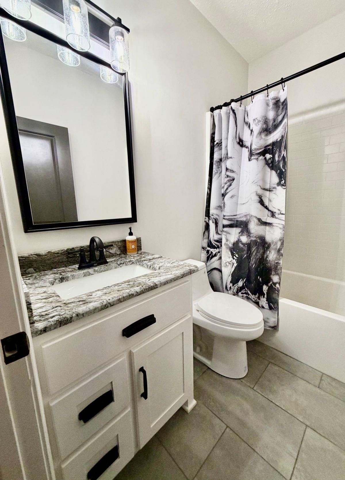 725 Crow Lane Counce, TN 38326 - Photo 10 of 19 a bathroom with a granite countertop sink toilet mirror and shower