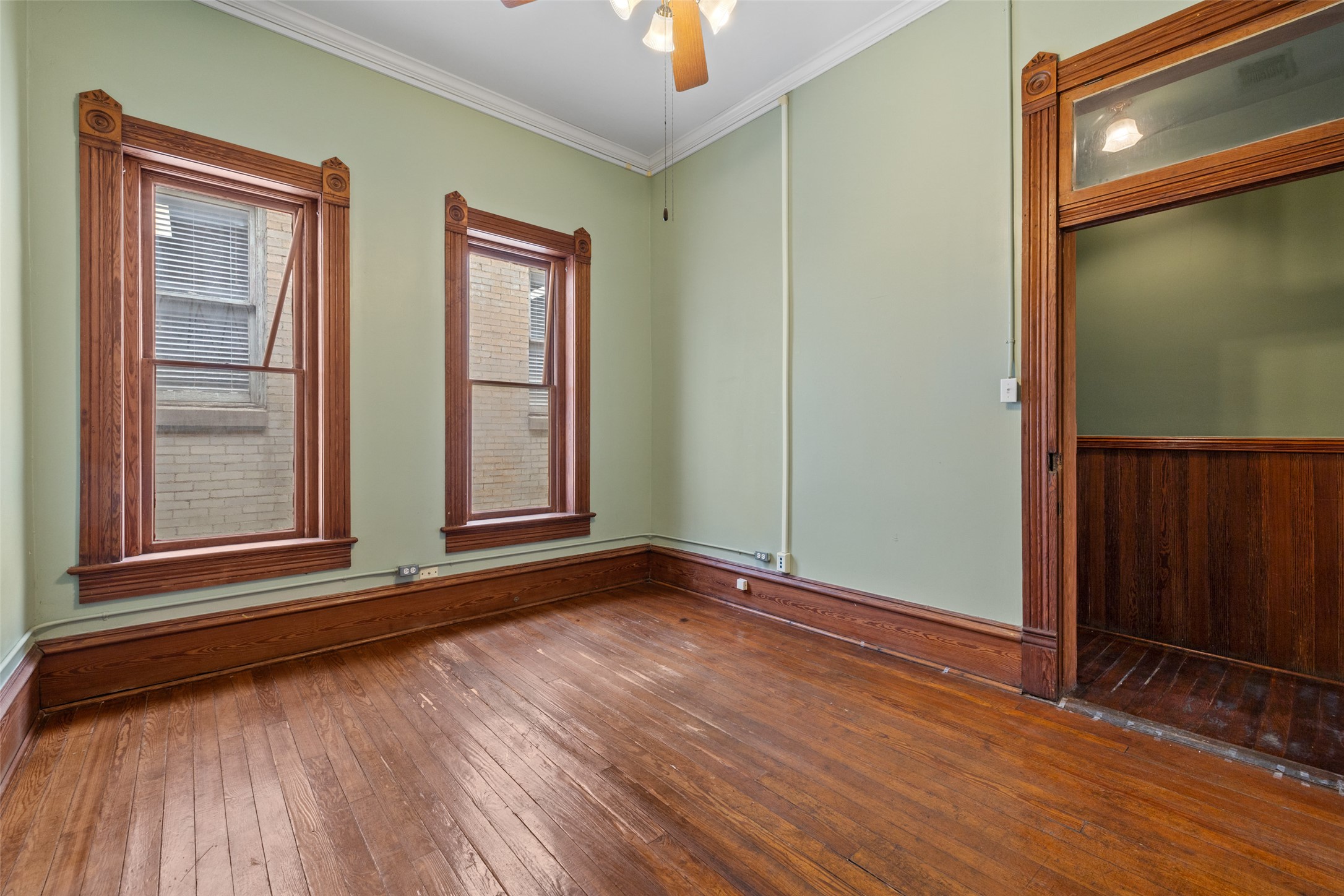 109 East 10th Street Austin, TX 78701 - Photo 13 of 38 Empty room featuring dark wood-style flooring, ceiling fan, and crown molding