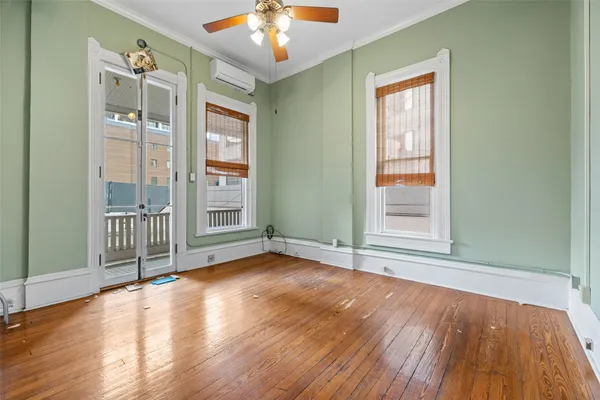 an empty room with wooden floor and windows
