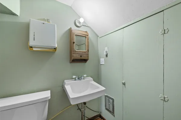 a bathroom with a toilet a sink and mirror