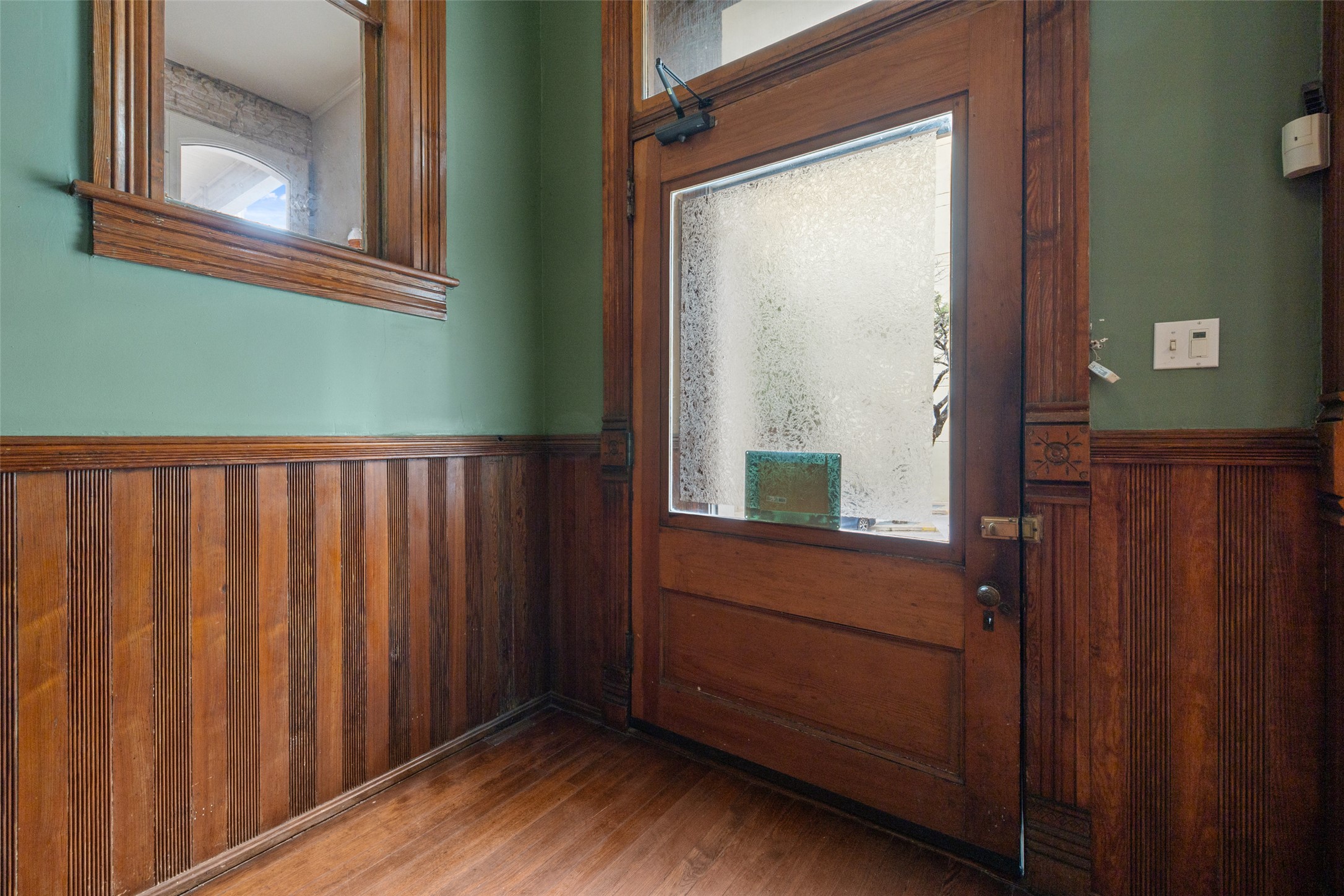109 East 10th Street Austin, TX 78701 - Photo 4 of 38 Entryway with a wainscoted wall, wooden walls, and wood finished floors