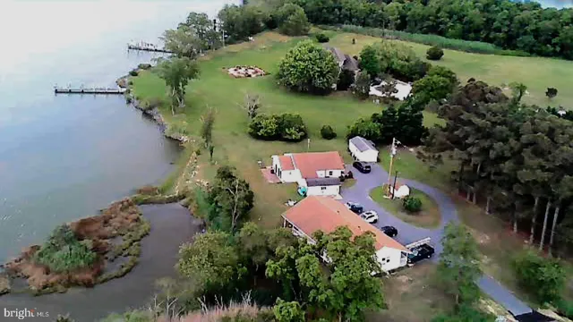 an aerial view of a house with a yard and lake view