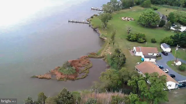 an aerial view of a house with a yard and lake view