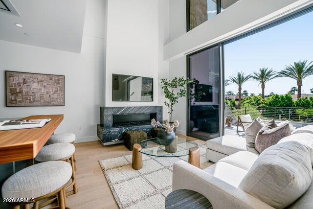 a living room with furniture potted plant a fireplace and a large window