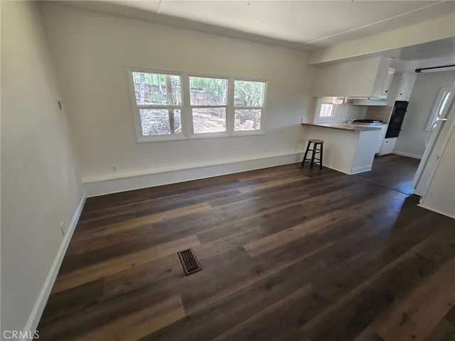 a room with wooden floor and windows