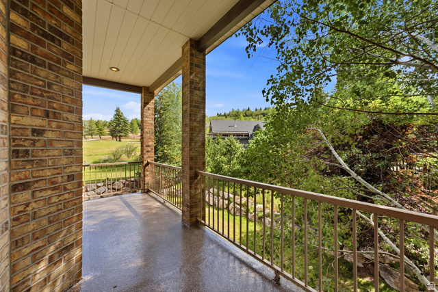 3535 Homestead Road Park City, UT 84098 - Photo 32 of 81 Covered balcony featuring brick columns, a metal railing, and a textured floor surface