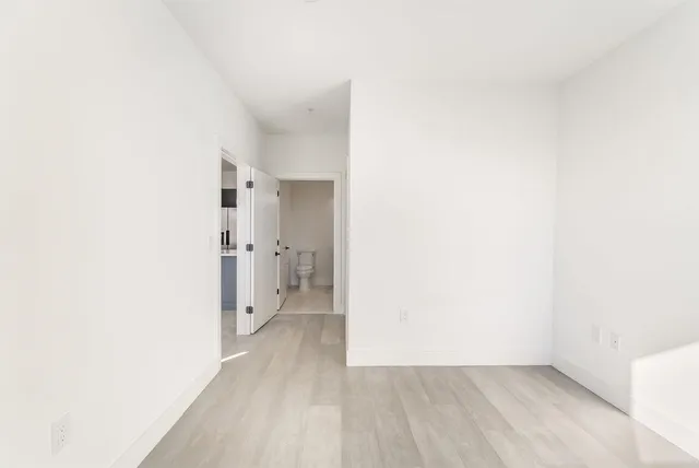 a view of an empty room with wooden floor