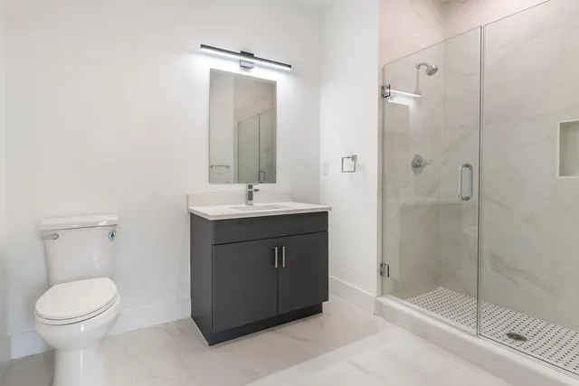 a bathroom with a sink a toilet and shower