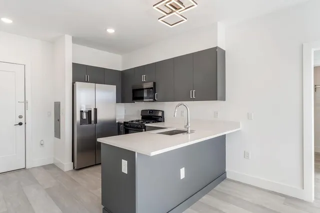 a kitchen with stainless steel appliances a refrigerator sink and microwave