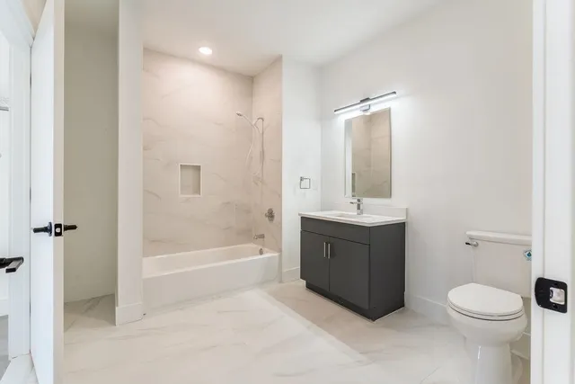 a bathroom with a sink a toilet and shower