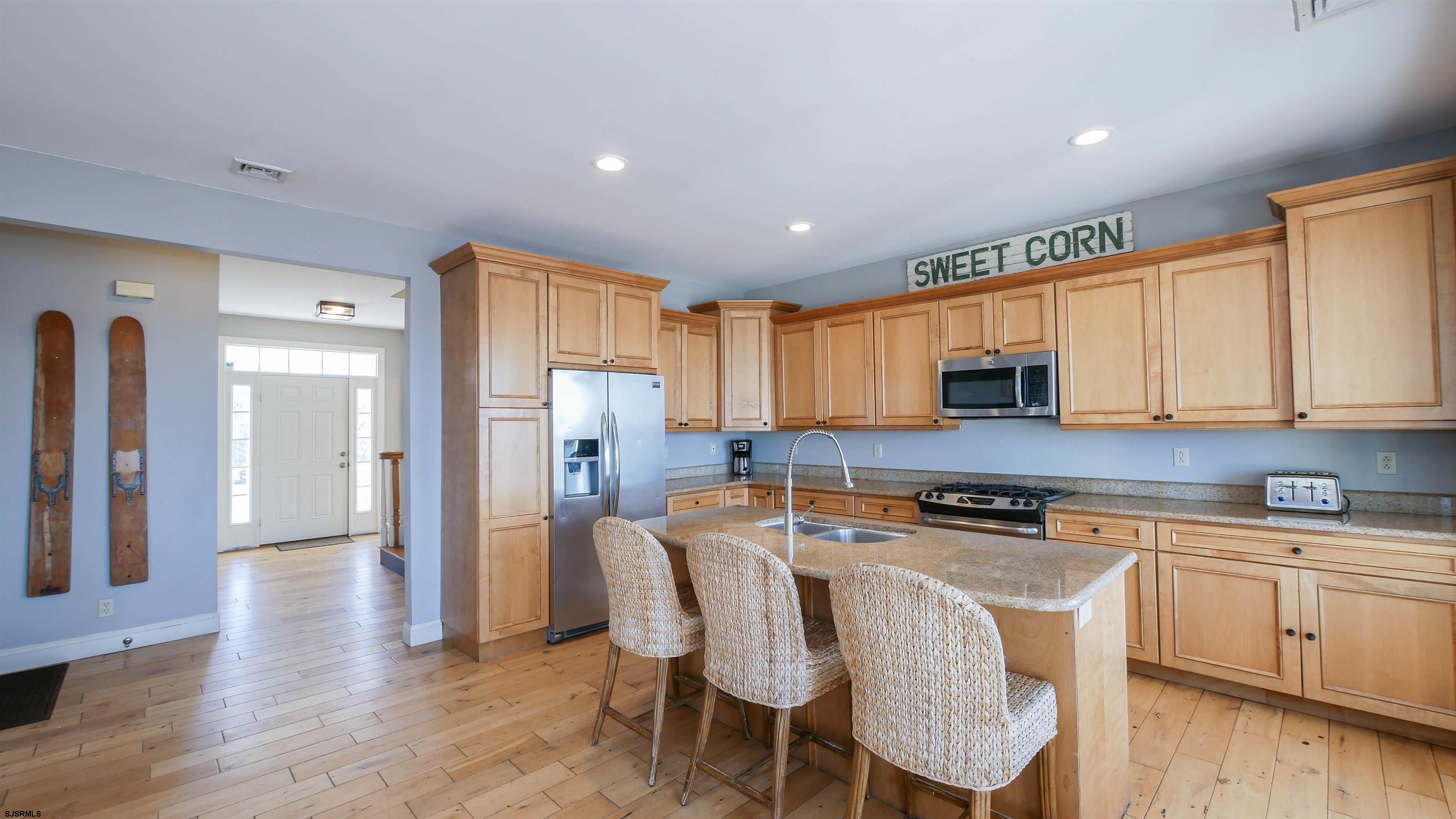2070 West Riverside Drive Atlantic City, NJ 08401 - Photo 12 of 40 a kitchen with stainless steel appliances white cabinets and wooden floor