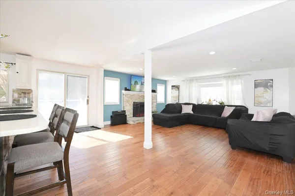 a living room with furniture and a dining table with wooden floor