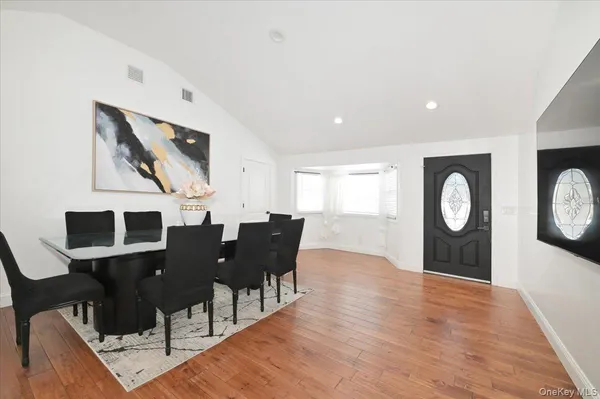a living room with furniture a table and wooden floor