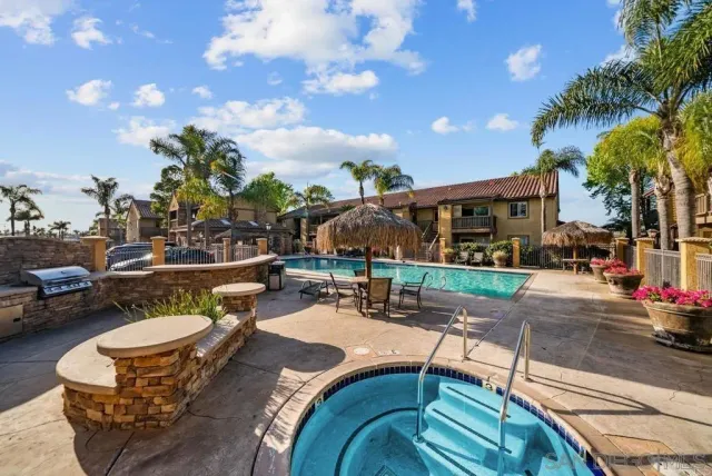 a view of a patio with couches table and chairs with potted plants and palm trees