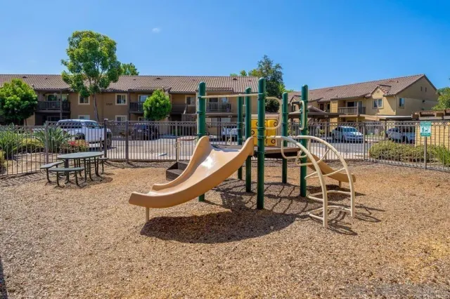a view of a house with backyard water fountain and sitting area