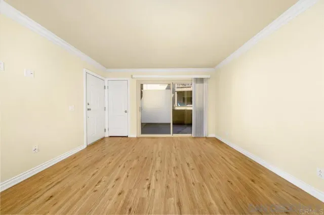 a view of empty room with wooden floor