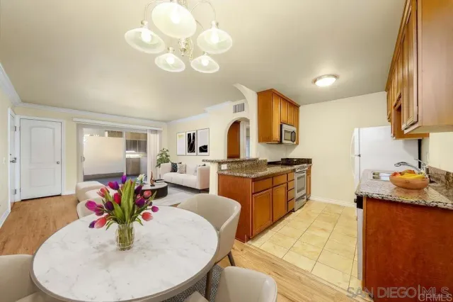 a kitchen with stainless steel appliances granite countertop a sink dishwasher and white cabinets with wooden floor