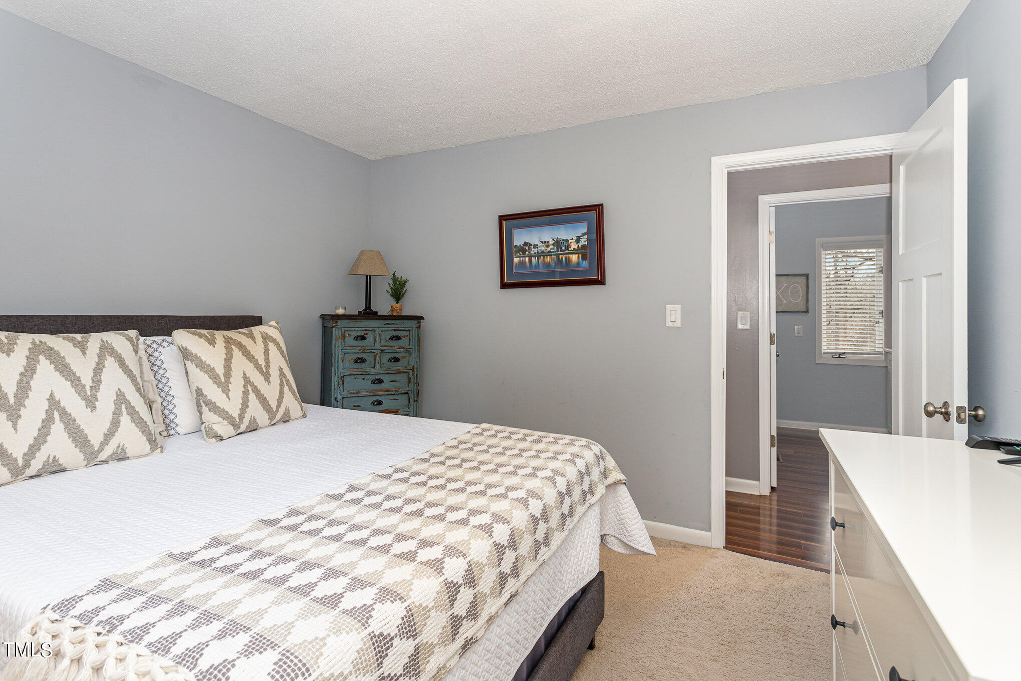 6913 Three Bridges Circle Raleigh, NC 27613 - Photo 22 of 28 a bedroom with a large bed and a chandelier