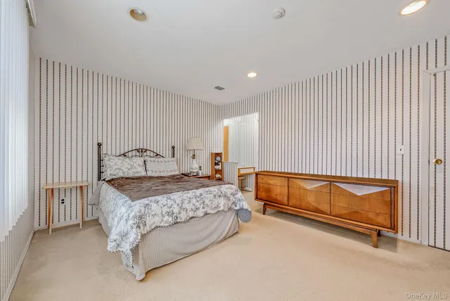 a bedroom with a bed and a dresser with mirror