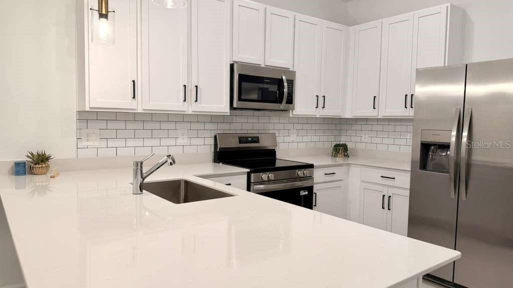 2735 Skyline Loop Kissimmee, FL 34758 - Photo 11 of 37 a kitchen with a refrigerator sink and stove top oven