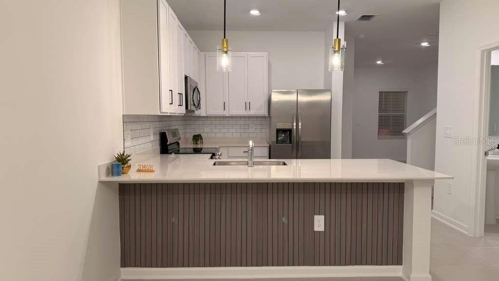 2735 Skyline Loop Kissimmee, FL 34758 - Photo 12 of 37 a kitchen with stainless steel appliances granite countertop a sink a refrigerator and a stove