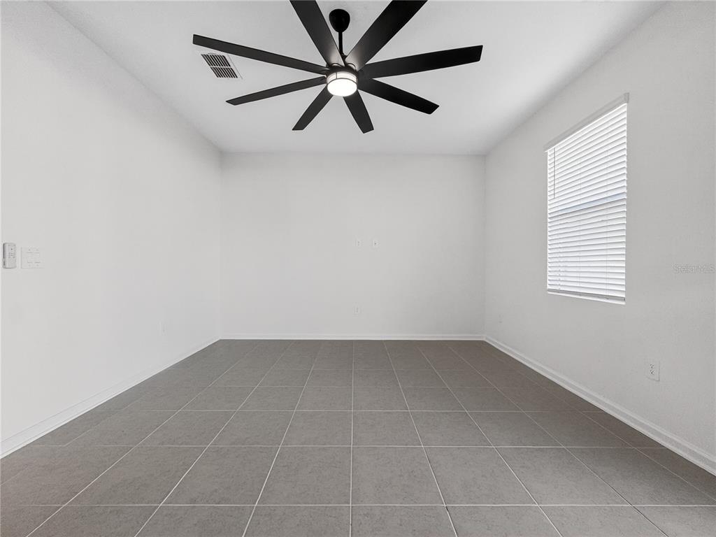 2735 Skyline Loop Kissimmee, FL 34758 - Photo 13 of 37 an empty room with a window and a fan
