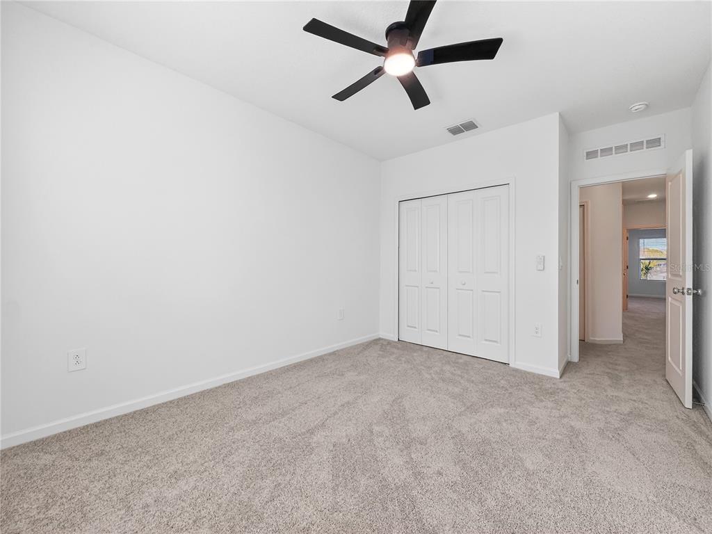 2735 Skyline Loop Kissimmee, FL 34758 - Photo 21 of 37 an empty room with closet and a ceiling fan