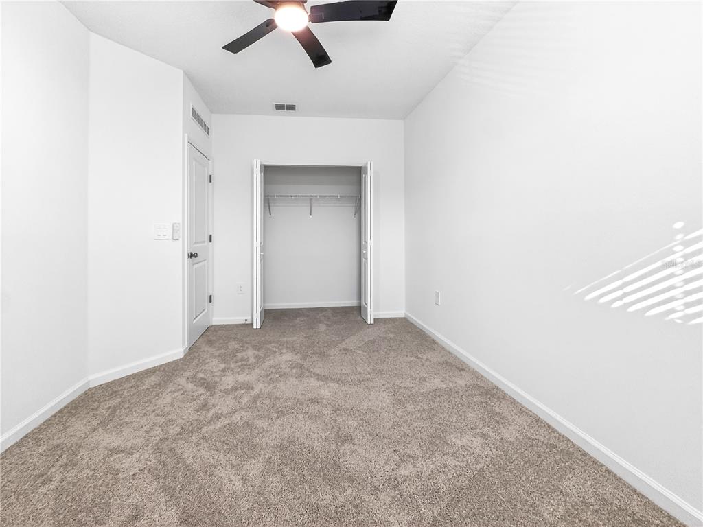 2735 Skyline Loop Kissimmee, FL 34758 - Photo 22 of 37 an empty room with a ceiling fan and carpet