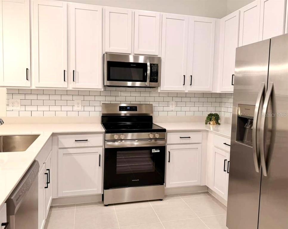 2735 Skyline Loop Kissimmee, FL 34758 - Photo 8 of 37 a kitchen with a stove microwave and refrigerator