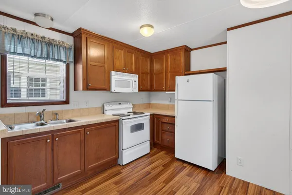 a kitchen with a sink a refrigerator and wooden cabinets