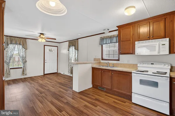 a kitchen with granite countertop wooden floors and white stainless steel appliances