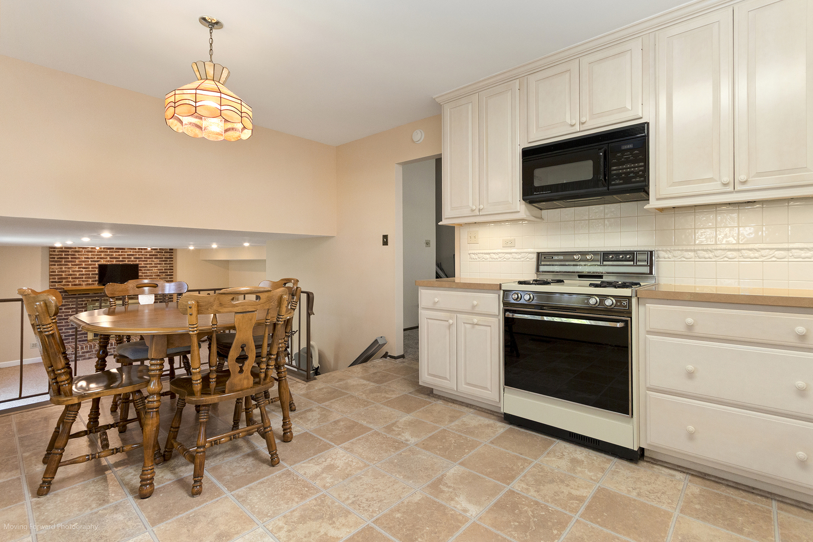 1570 West Goldengate Drive Addison, IL 60101 - Photo 8 of 34 a kitchen with stainless steel appliances granite countertop a stove a microwave a dining table and chairs