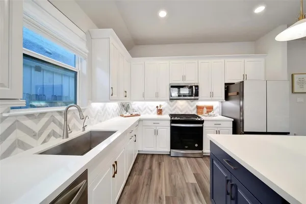 a kitchen with a stove a counter top space and a dining table with wooden floor