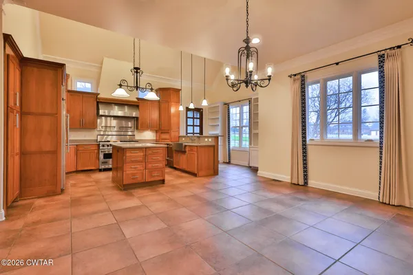 a view of kitchen with stainless steel appliances granite countertop a refrigerator and a stove top oven