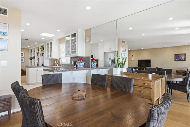 a living room with furniture kitchen area and a flat screen tv