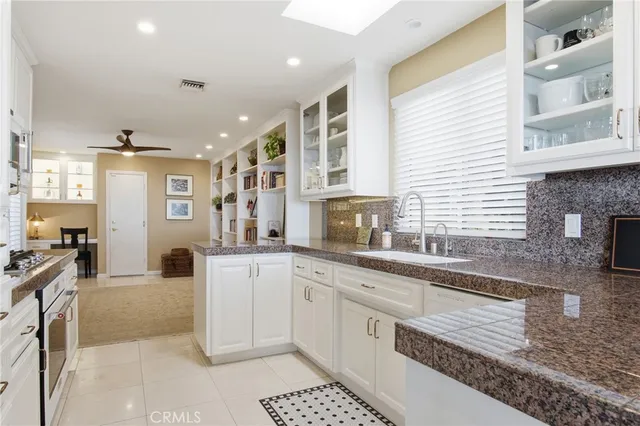 a large kitchen with stainless steel appliances granite countertop a sink and cabinets