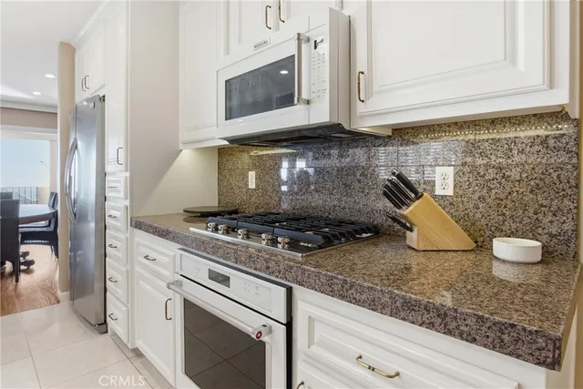 a kitchen with granite countertop a stove and a microwave