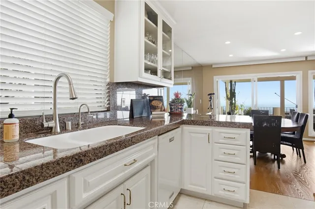 a kitchen with granite countertop a sink a counter space and cabinets