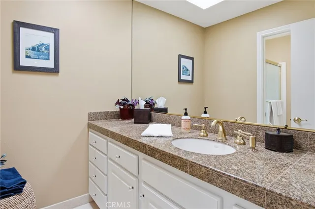 a bathroom with a granite countertop sink and a mirror