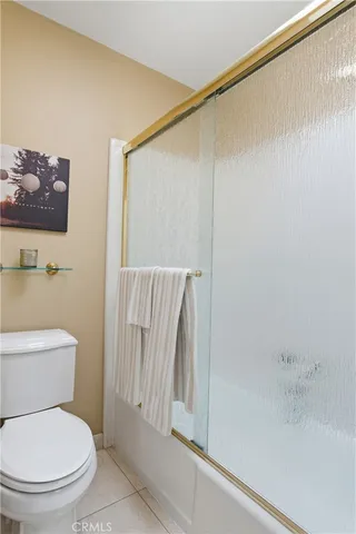 a white toilet sitting next to a shower