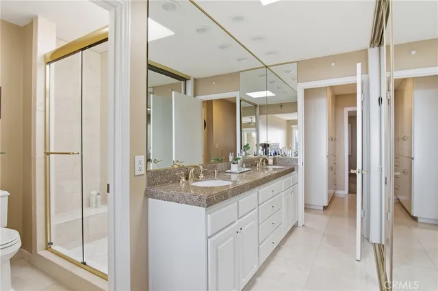 a bathroom with a granite countertop sink two mirror and a shower