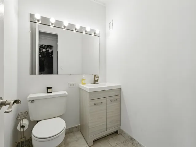 a bathroom with a toilet a sink and mirror
