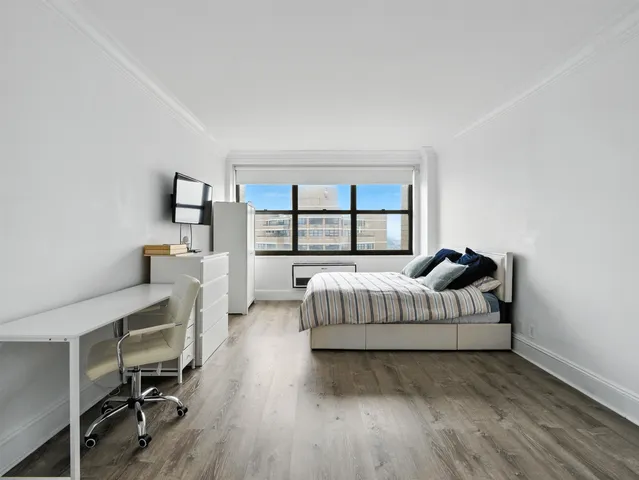 a living room with hard wood floors furniture and a window