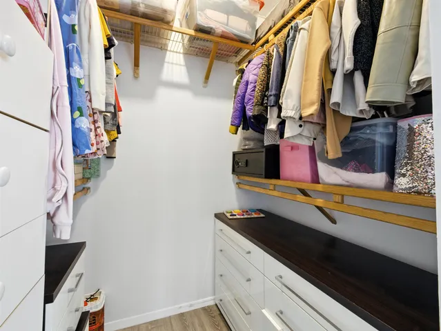 a view of walk in closet with clothes and shoes