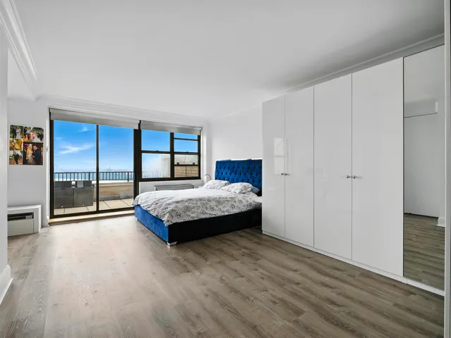 a spacious bedroom with a bed and large window