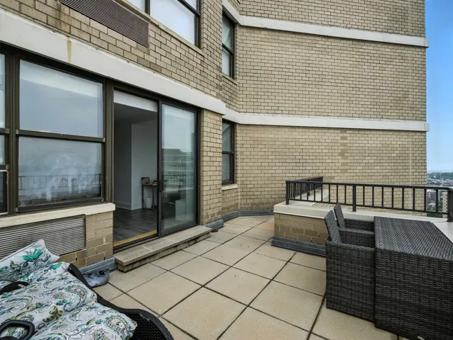 a view of a balcony with two chairs and a barbeque